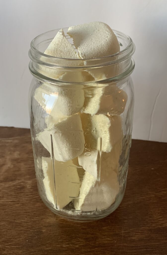 jar full of lemon DIY dishwasher tablets on a wooden table