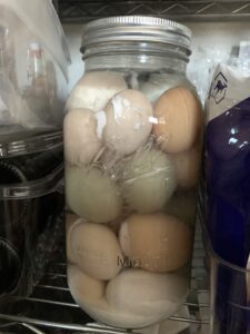 water glassed eggs in a half gallon jar sitting on a pantry shelf