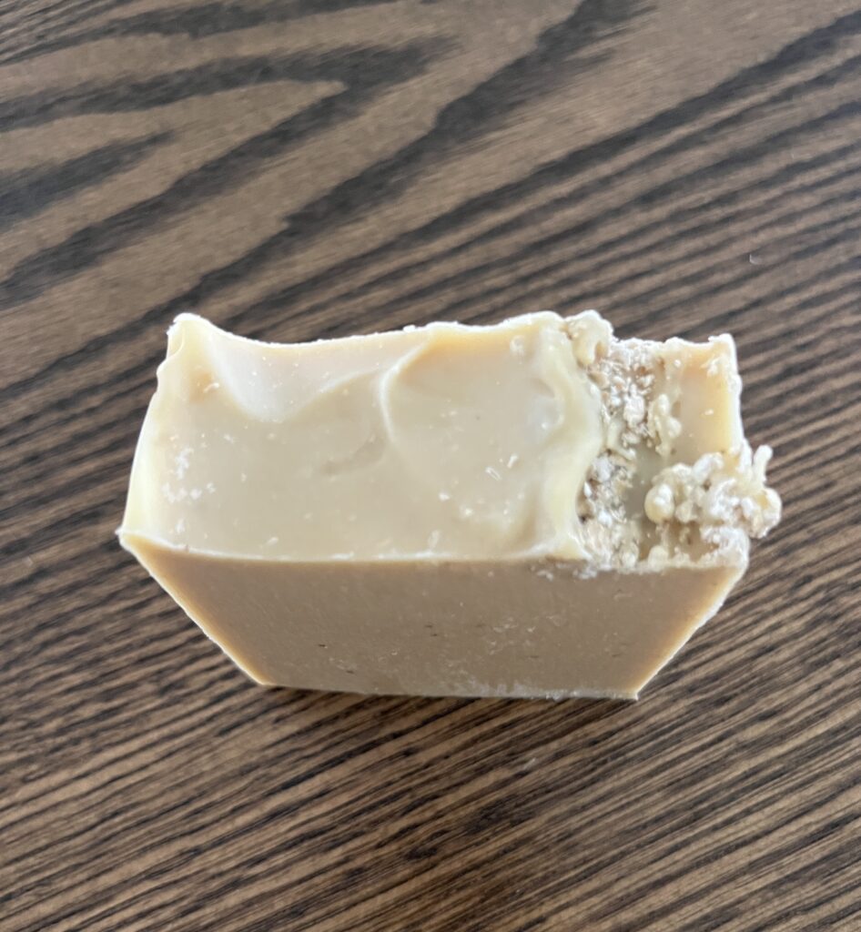 goats milk, oatmeal, and honey single soap bar sitting on a wooden table