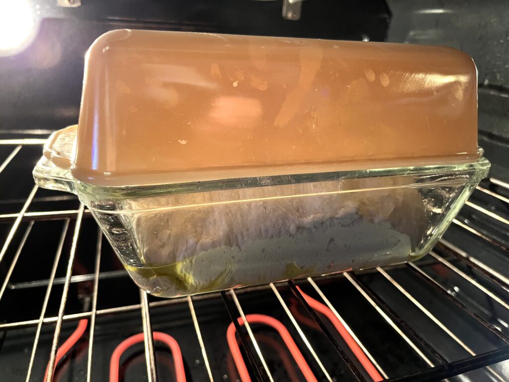 loaf pan stacked on top of a loaf pan inside of an oven that is on