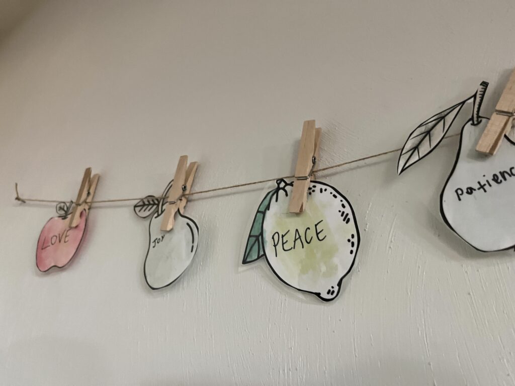 four water color fruit of the spirit cut out and strung on a twine string