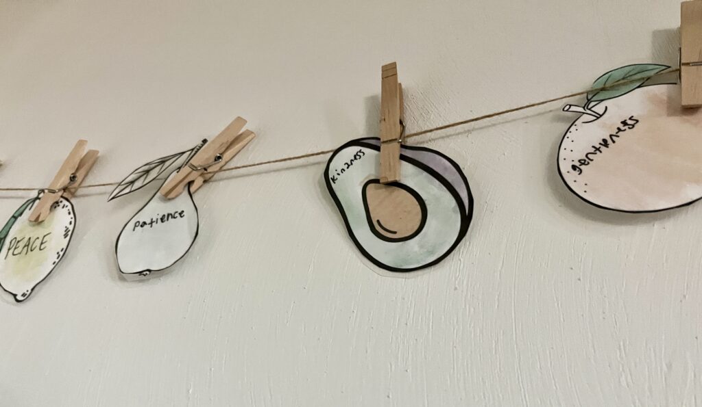 four water color fruit of the spirit cut out and strung on a twine string