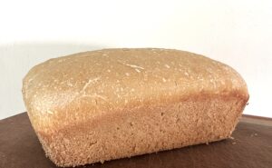 loaf of freshly milled sourdough bread on a wooden cutting board
