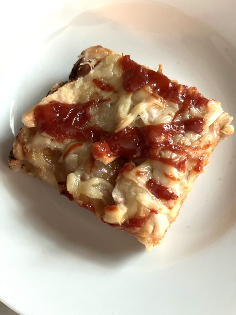 single square barbecue chicken pizza slice on a white plate