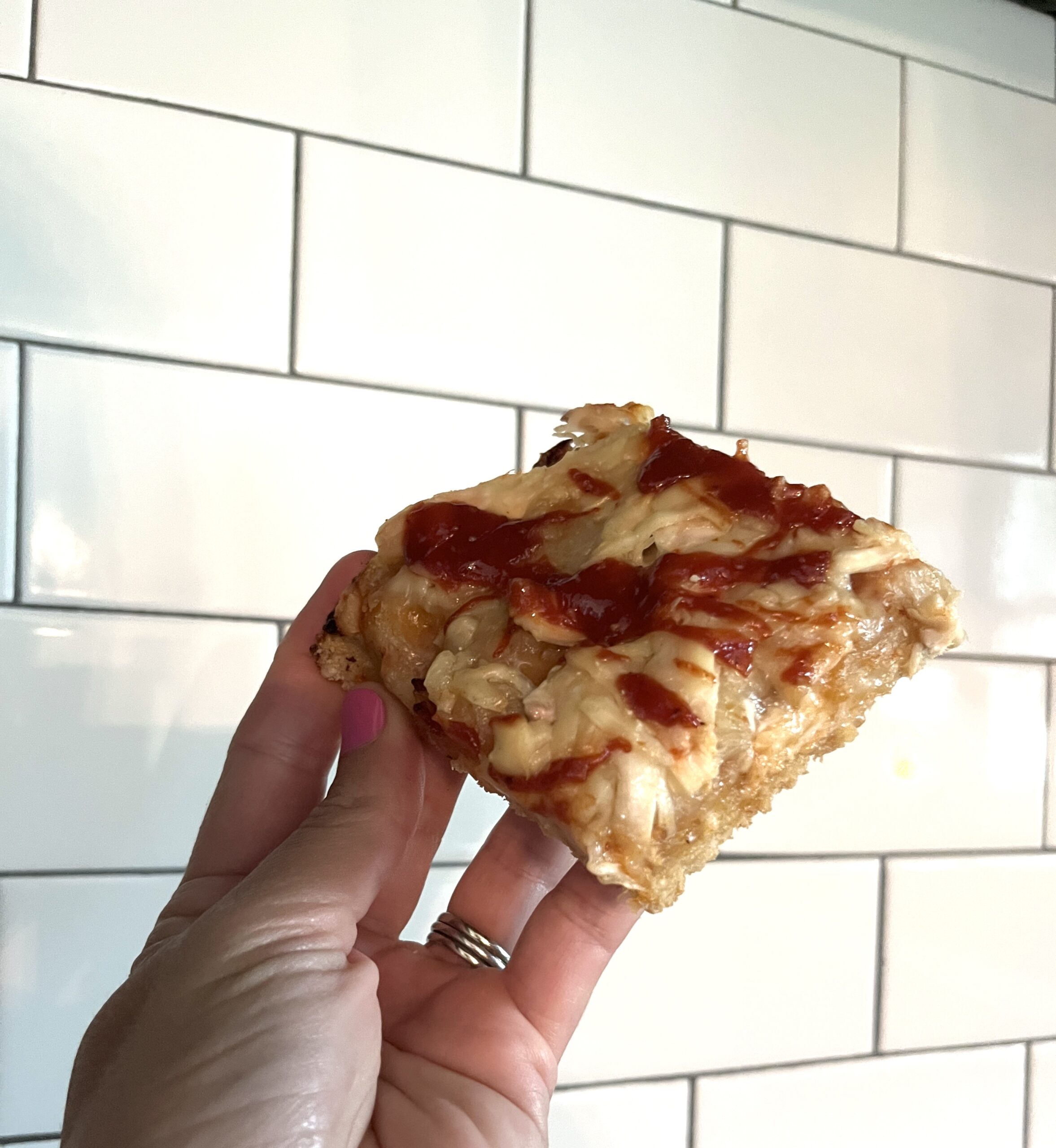 hand holding single square barbecue chicken pizza slice