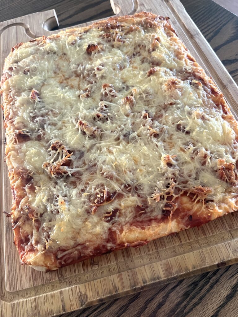 large smoked sourdough pizza on a wooden cutting board