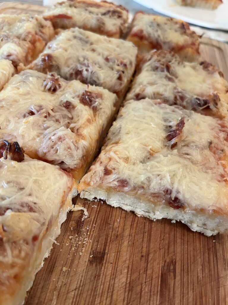 close shot view of sliced into squares smoked sourdough pizza