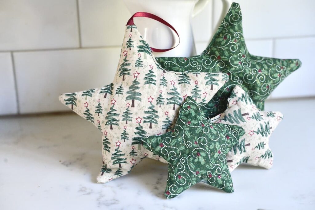 four green and white fabric stars on a marble counter top with a white subway tile backsplash
