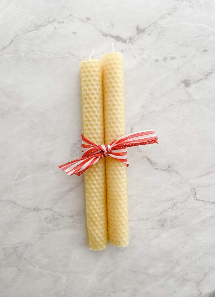 diy beeswax candles rolled up lying on a marble countertop make a great idea for a Christmas craft
