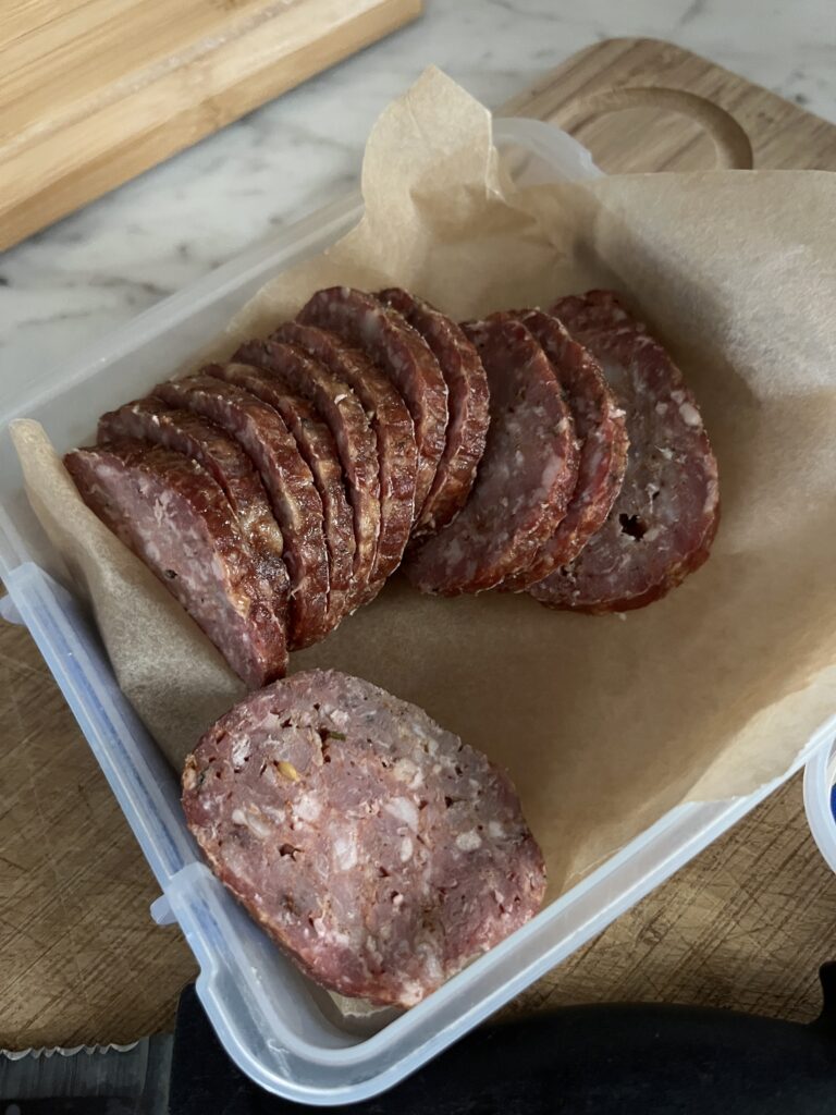 slices of pepperoni inside of a square container with no lid