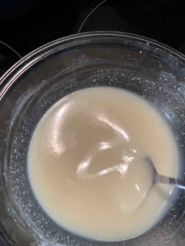 goats milk and lye melted down in a clear bowl into a creamy beige colored liquid