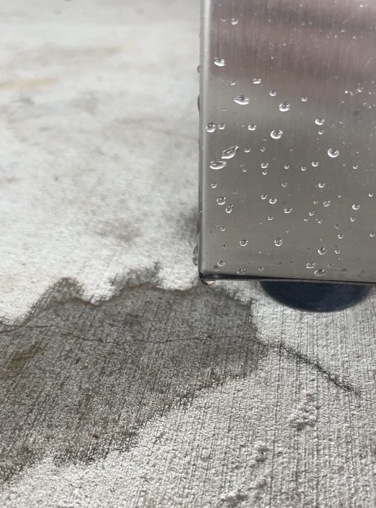 water leaking from corner of stainless steel Strombergs chicken scalder onto cement