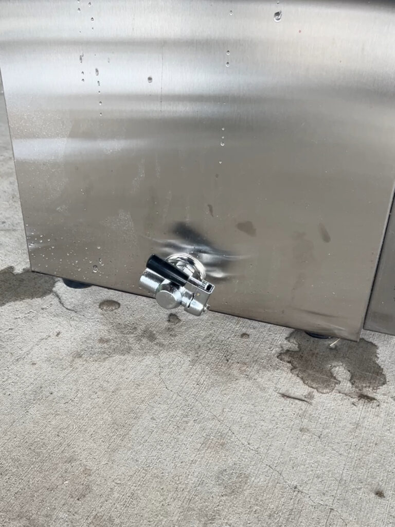 Stainless steel Strombergs Chicken scalder on cement floor leaking from 2 corners