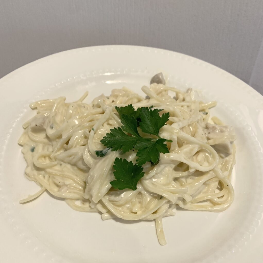 white plate of Alfredo-covered noodles topped with fresh parsley leaves make an excellent from scratch lunch hack