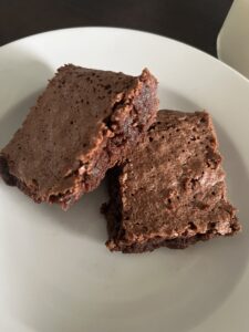 two freshly milled chocolate Brownies on a white plate