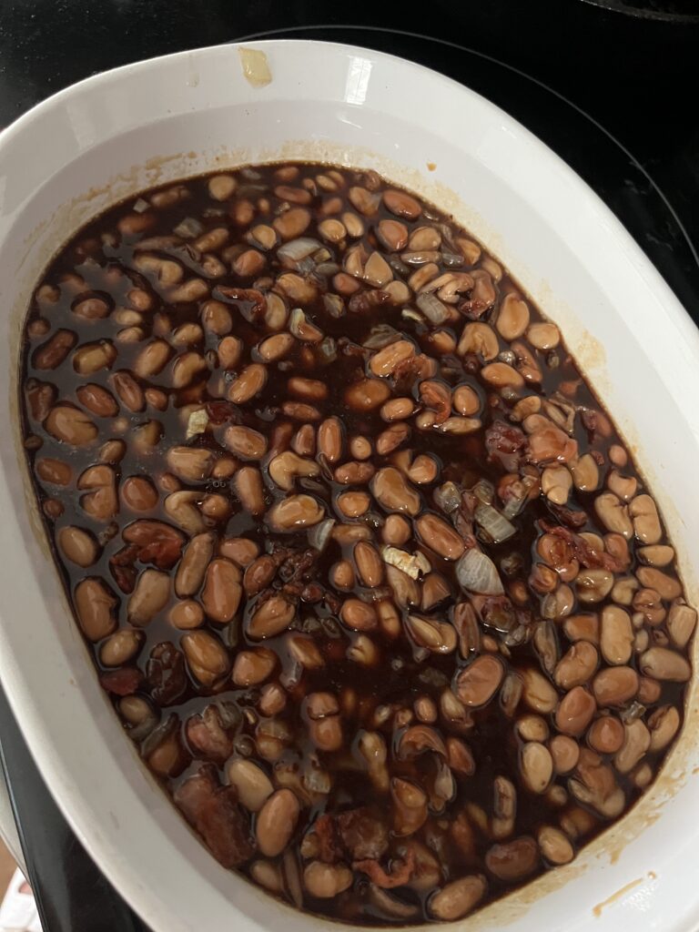 white casserole dish filled with homemade baked beans mixture